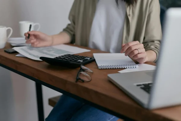 working at desk with screen papers and calculator