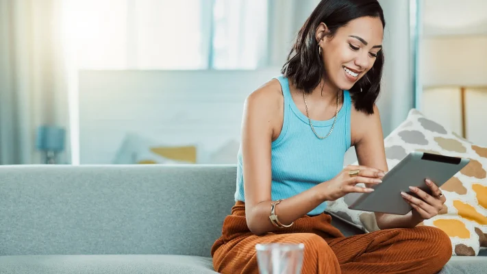 Woman checking an online homeowner portal for HOA account balance and community information.
