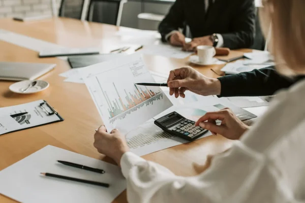 people sitting at desk evaluating graphs and calculations